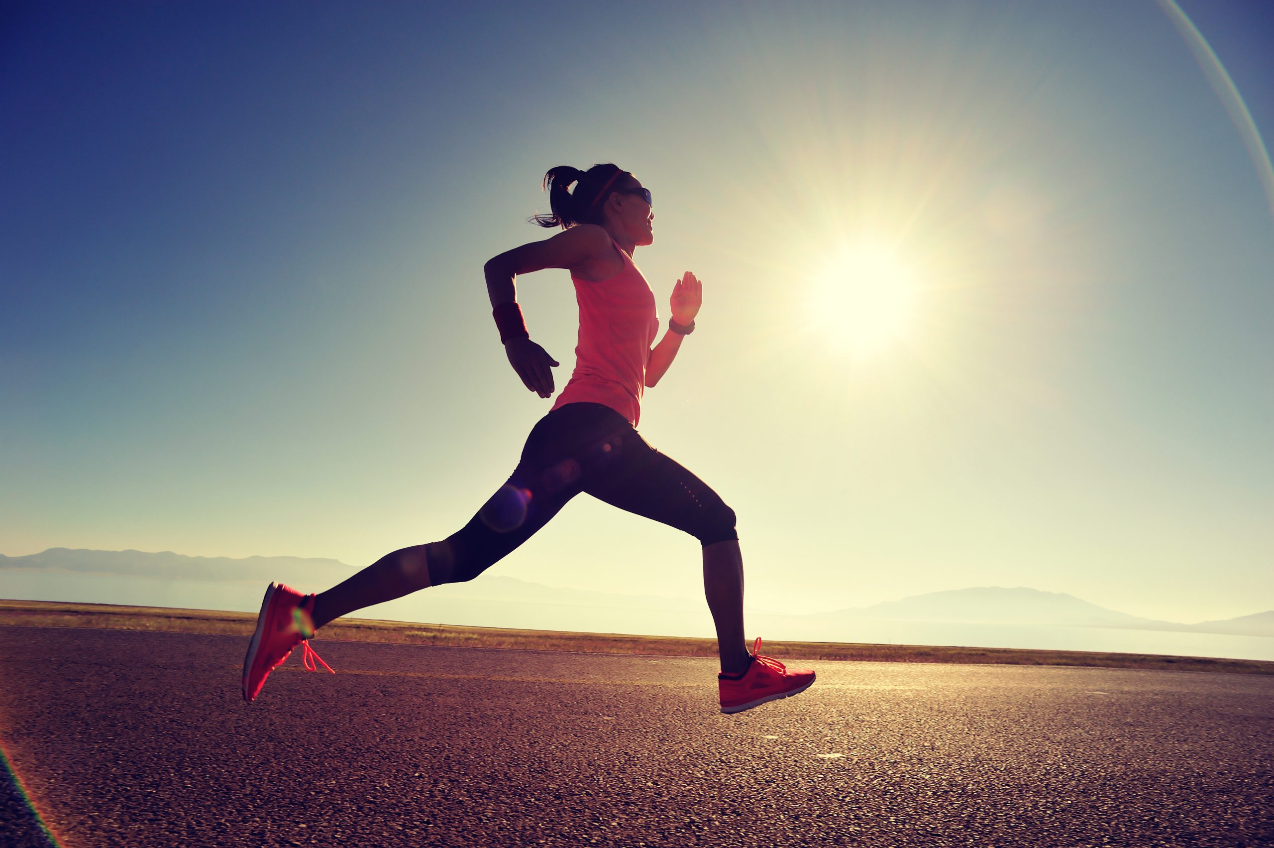 young fitness woman runner running on sunrise seaside trail